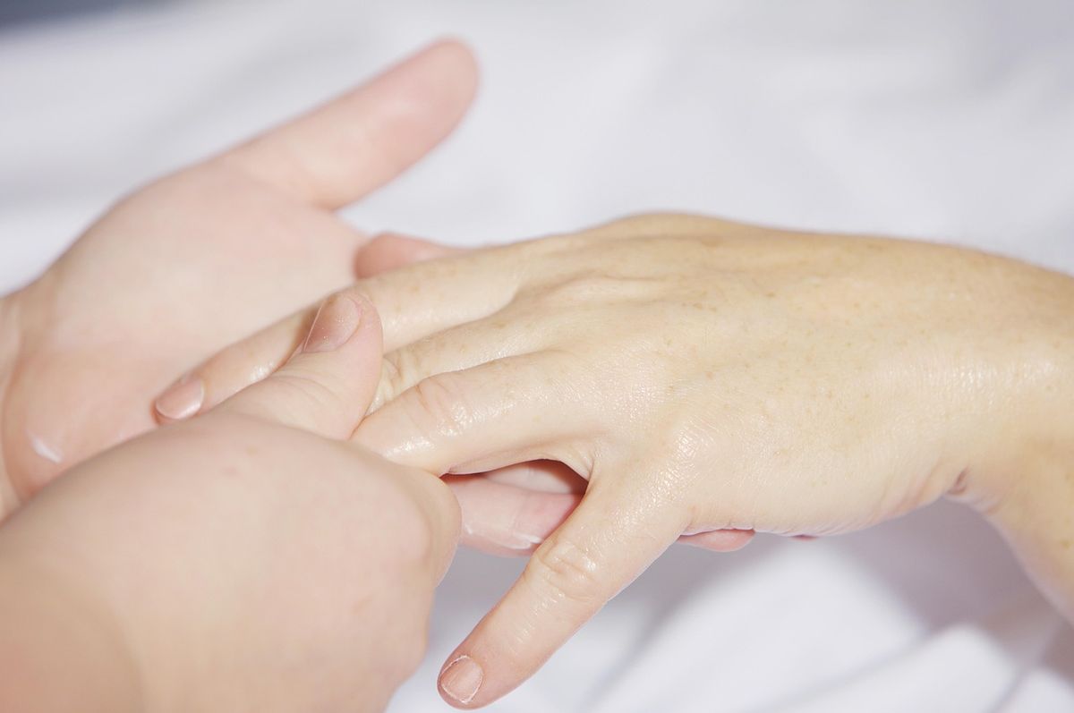 Close-up of a therapist's hands giving a gentle hand treatment